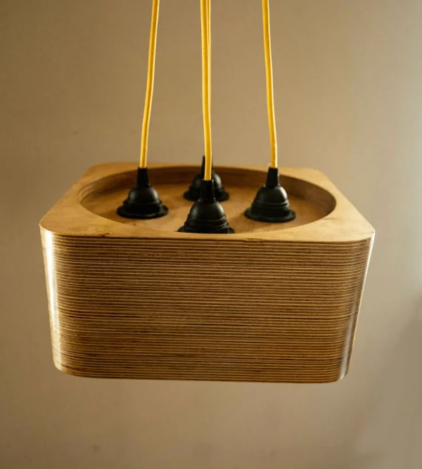 Modern 4 Bulb Square Pendant Light with exposed plywood look & hanging from green fabric cable