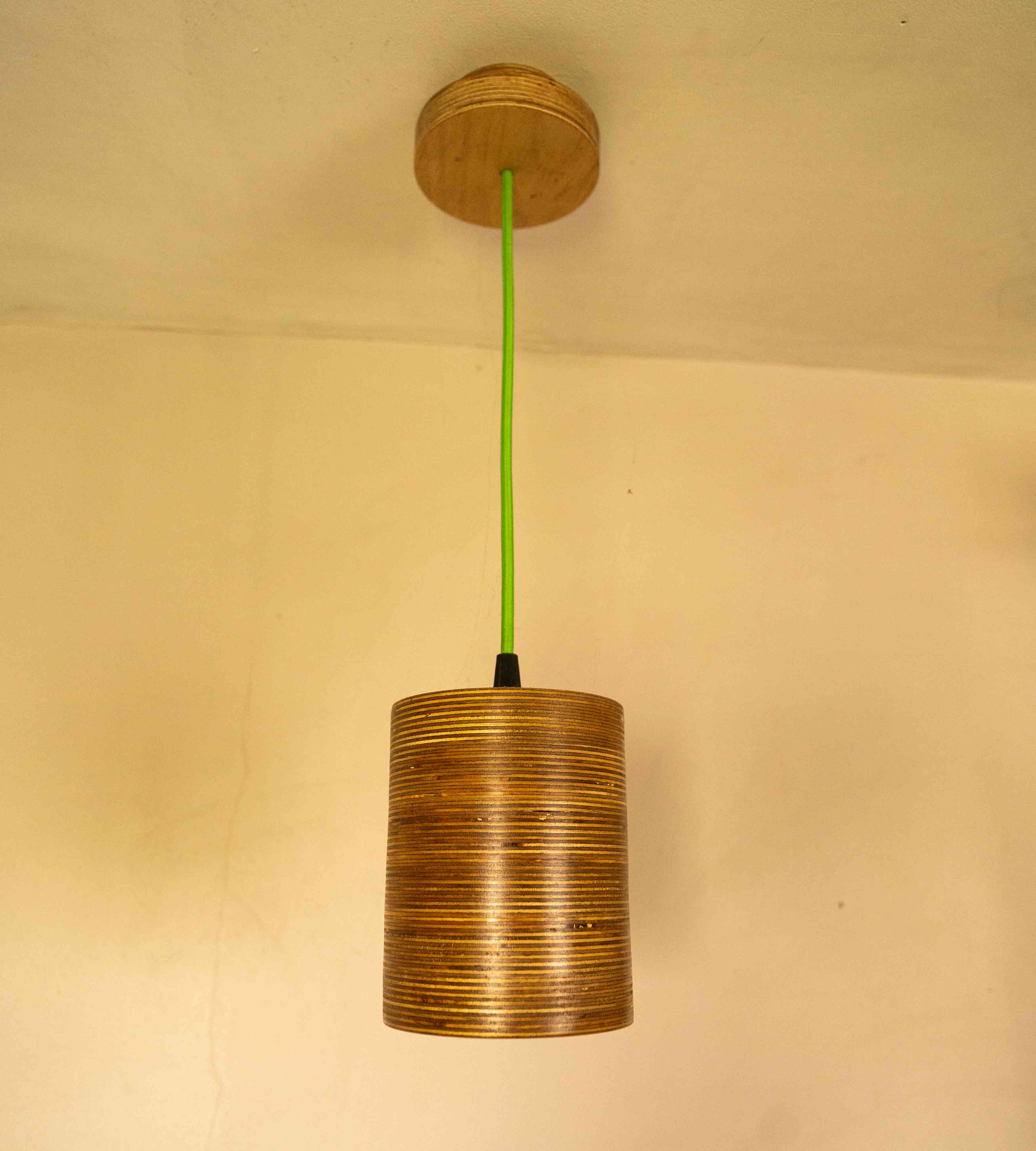 Contemporary Single Bulb Round Pendant Light with exposed plywood look & hanging from green fabric cable